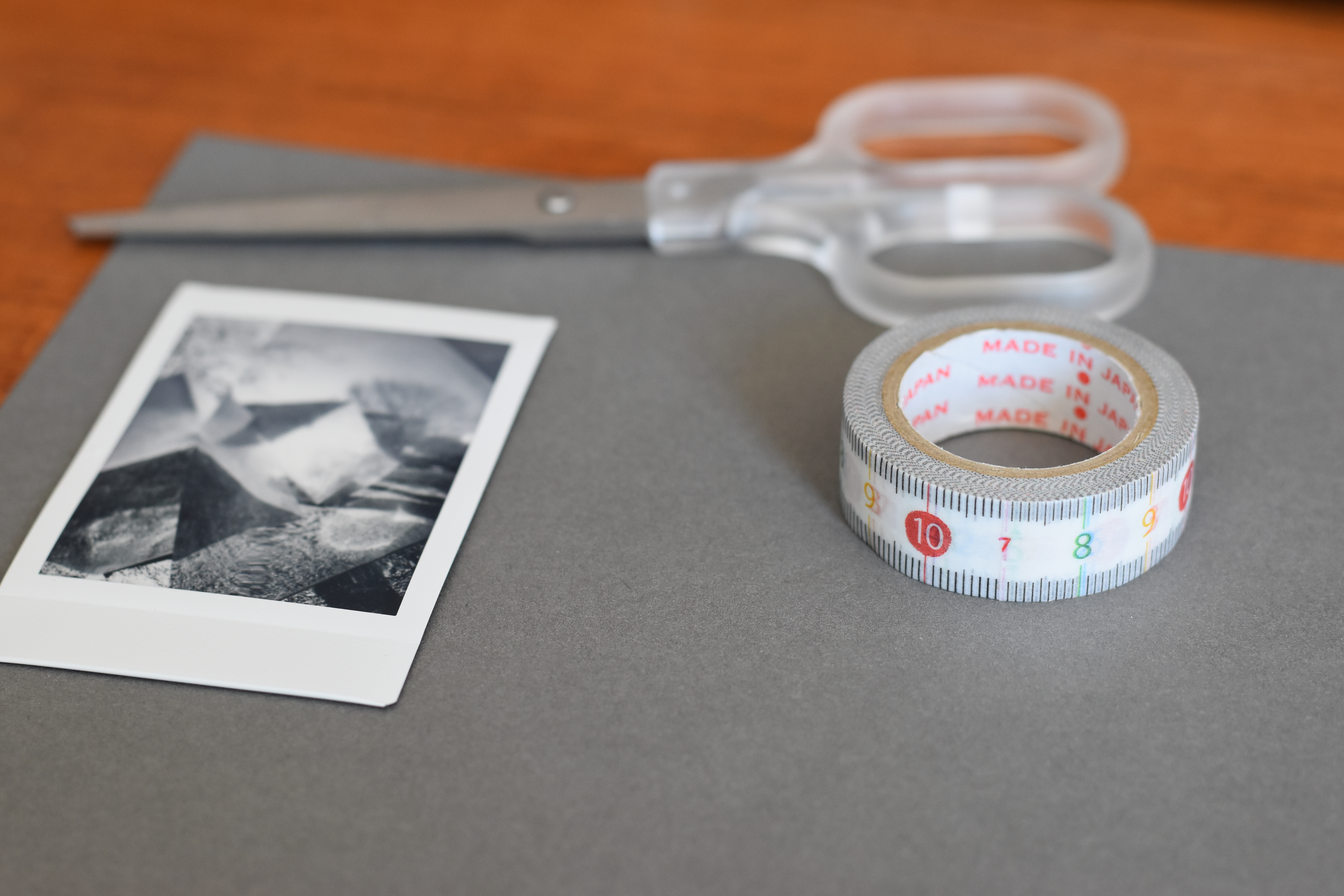 Scissors, 15mm washi tape, an Instax mini photo, a grey scrapbooking page